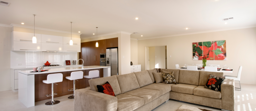 Modern living area with sectional sofa and kitchen with wood cabinetry